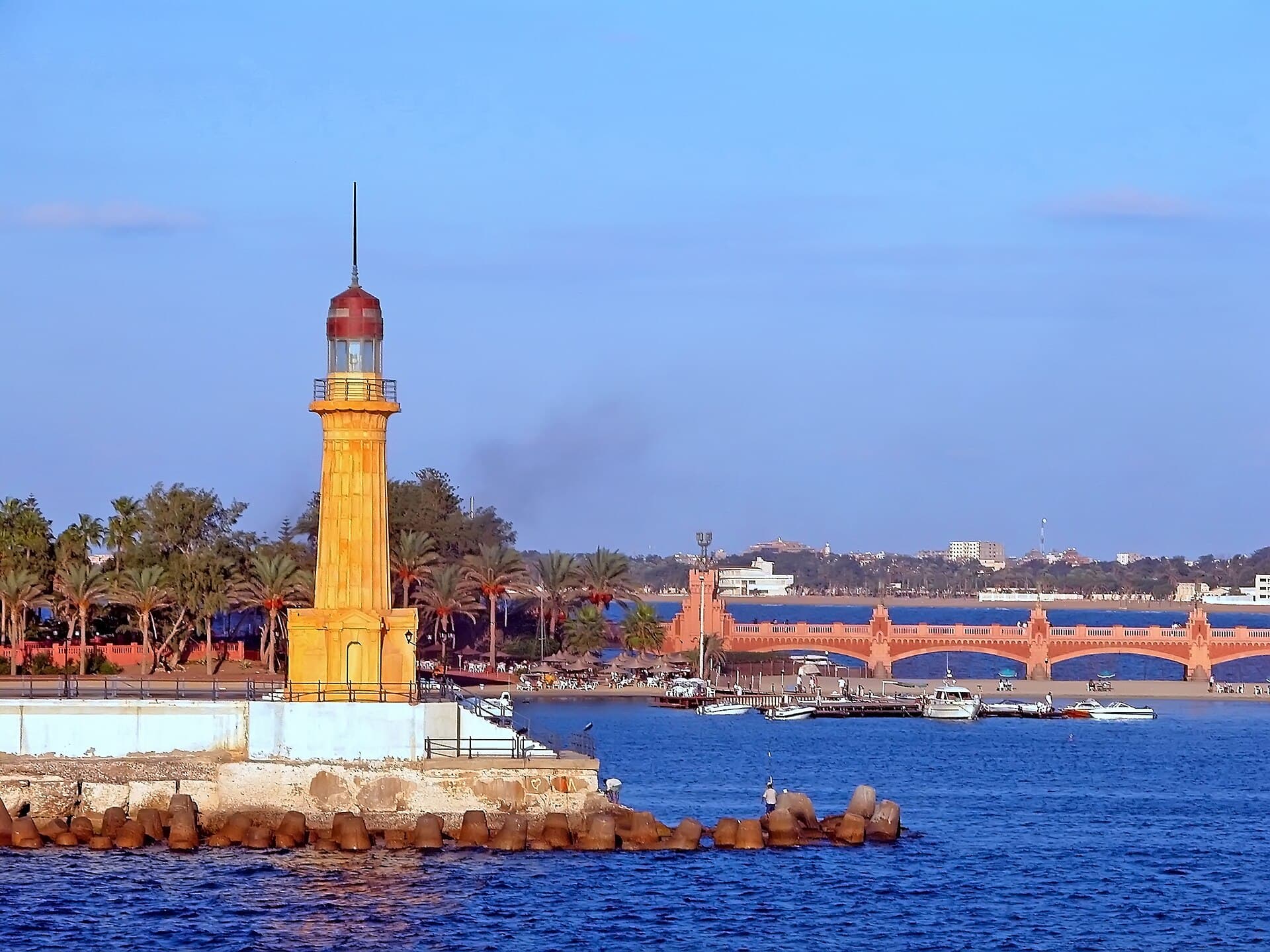 منارة المنتزه البيضاء ذات الأشرطة الحمراء بين أشجار الحدائق